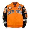 Pelle Leather Jacket Orange body with black leather sleeves and NY Knicks Logos in Blue, Orange & Black Available at Brick City Leather